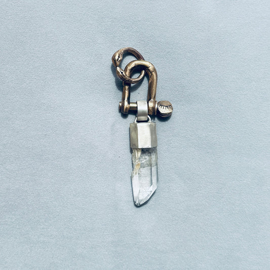 Crystal pendant with metal clasp on a light blue background